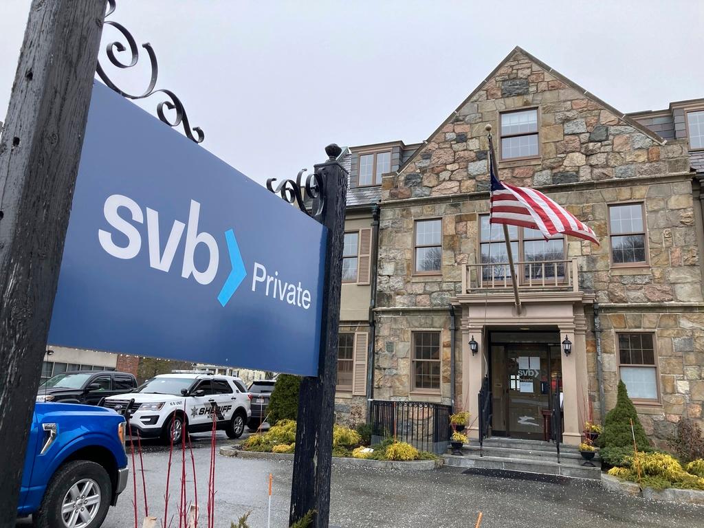 Vehicles are parked outside a Silicon Valley Bank branch in Wellesley, Mass., on Saturday, March 11, 2023. 