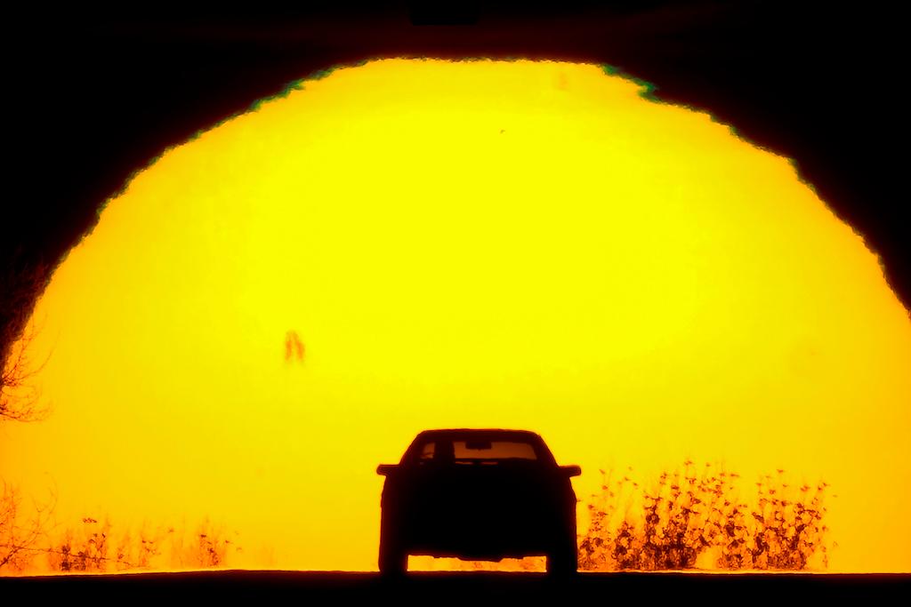 A motorist is silhouetted against the setting sun on the eve of the vernal equinox, Sunday, March 19, 2023, in Shawnee, Kan.
