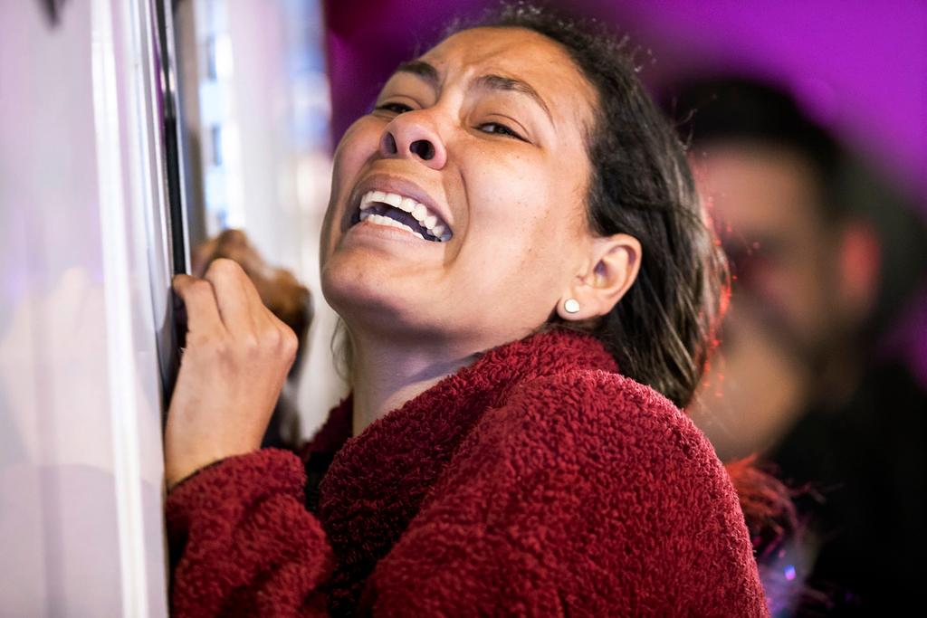 A migrant cries leaning on an ambulance as a person she knows is attended by medics after a fire broke out at the Mexican Immigration Detention center