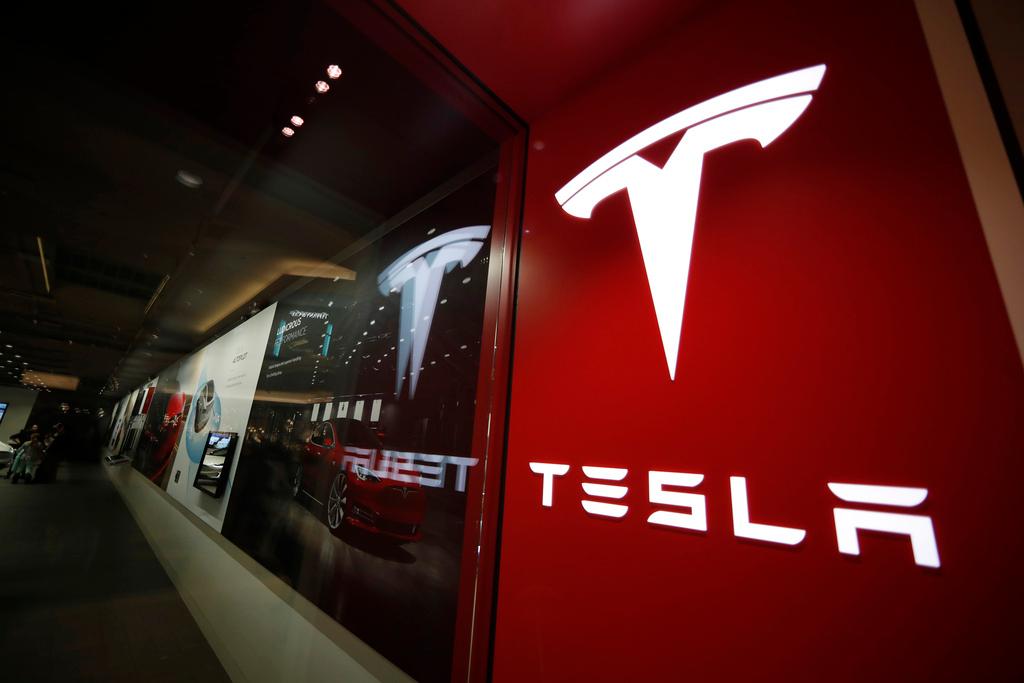 A sign bearing the Tesla company logo is displayed outside a Tesla store in Cherry Creek Mall in Denver, Colorado.