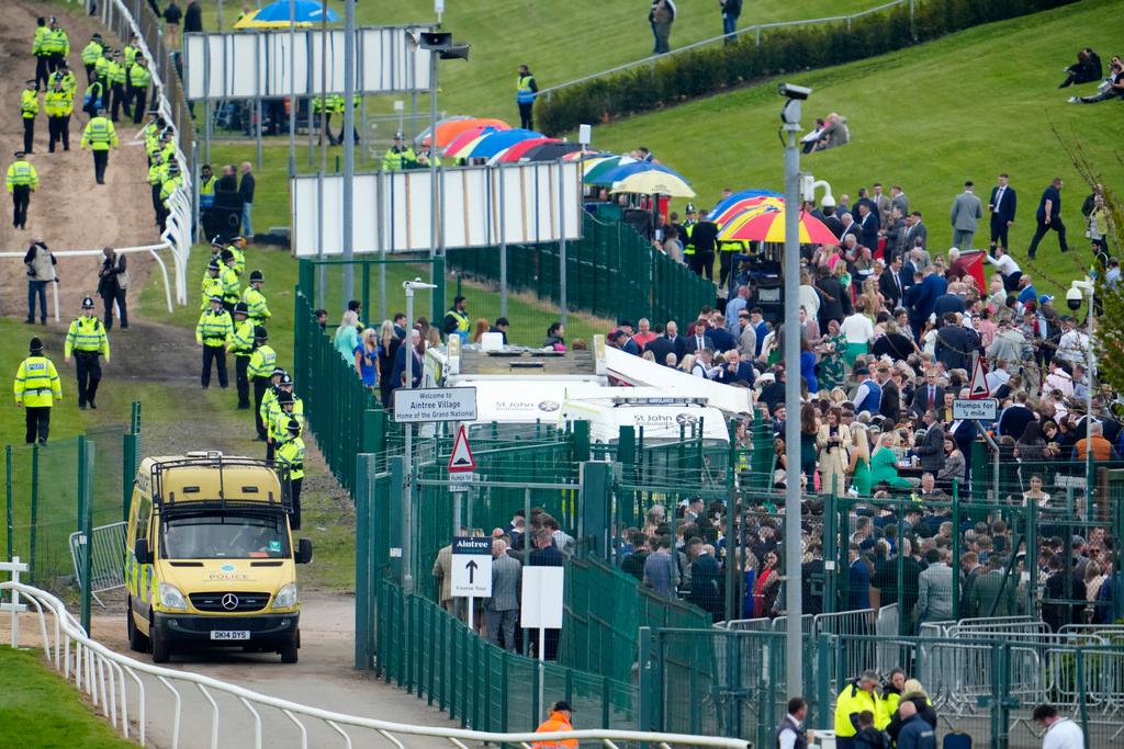 Police stand guard around the perimiter of the course after threats of disruption by animal rights activists before the Grand National horse race in Liverpool, England, Saturday, April 15, 2023. 