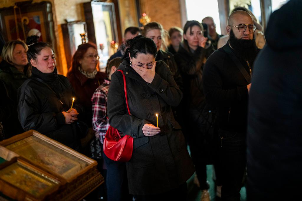 A woman cries during the funeral of Sofia Shulha, 11, and Pysarev Kiriusha, 17, in Uman, central Ukraine