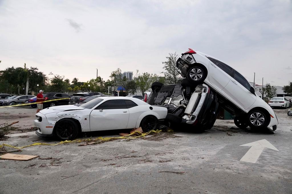 Damaged cars appear in a parking lot after a reported tornado hit the area Sunday, April 30, 2023 in Palm Beach Gardens, Fla. 