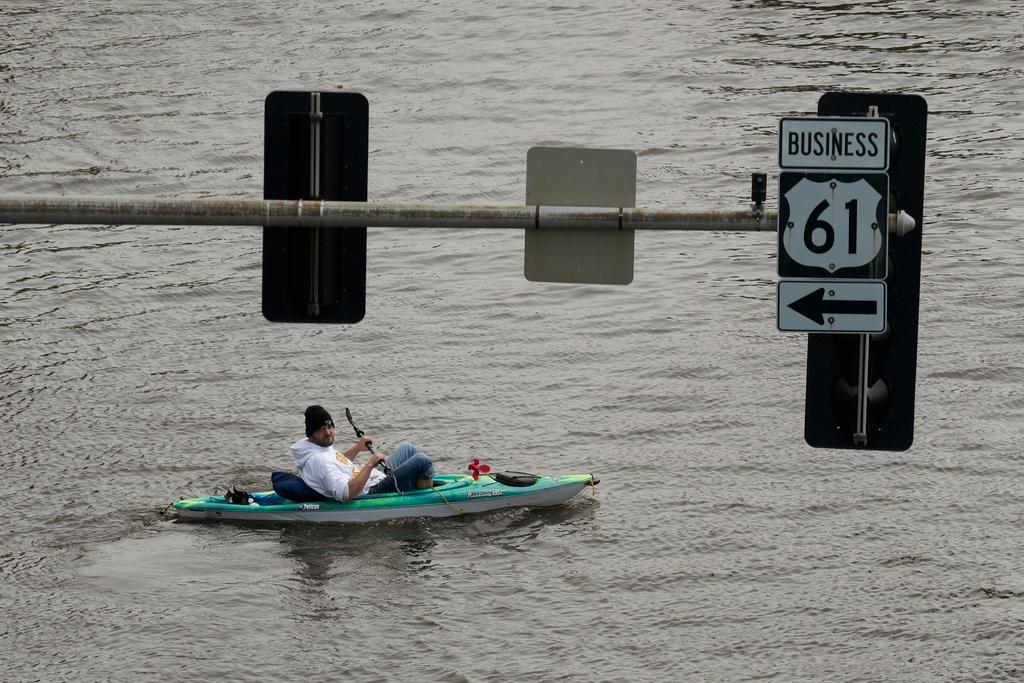 A kayaker floats down a flooded street, Monday, May 1, 2023, in downtown Davenport, Iowa. 