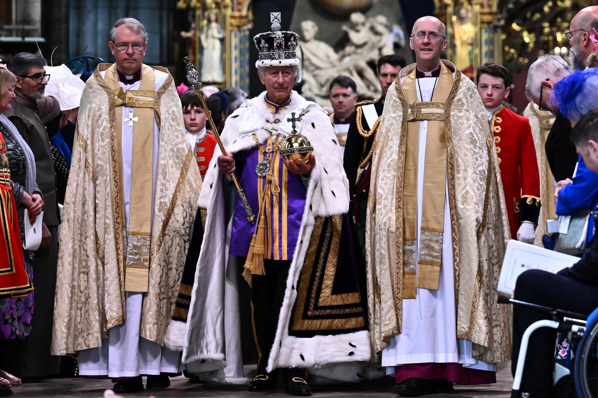 Britain's King Charles III wearing the Imperial state Crown and carrying the Sovereign's Orb and Sceptre leaves Westminster Abbey after coronation in central London Saturday, May 6, 2023.