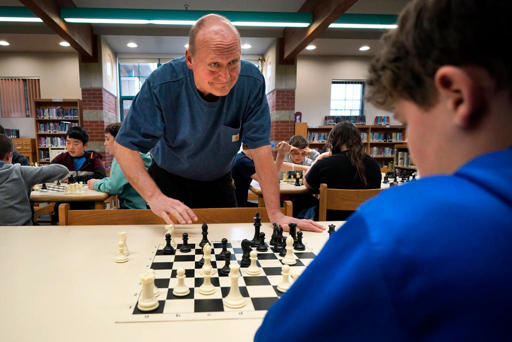 Custodian and chess coach David Bishop challenges 6th-grader Owen Isenhour during after-school practice