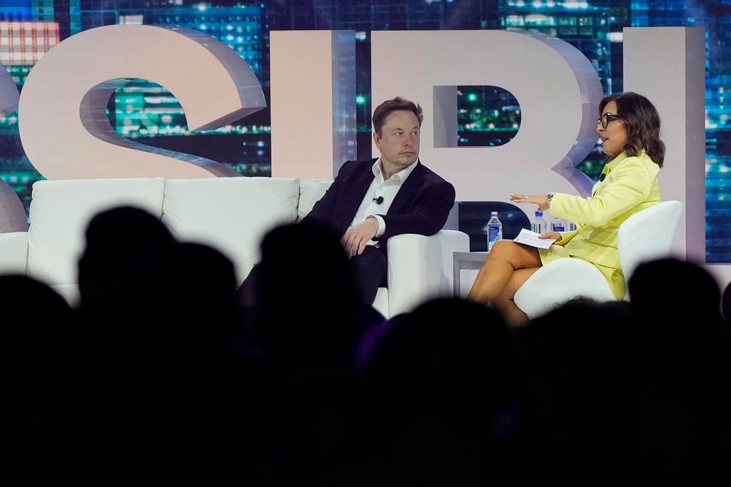Twitter CEO Elon Musk, center, speaks with Linda Yaccarino, chairman of global advertising and partnerships for NBC, at the POSSIBLE marketing conference, Tuesday, April 18
