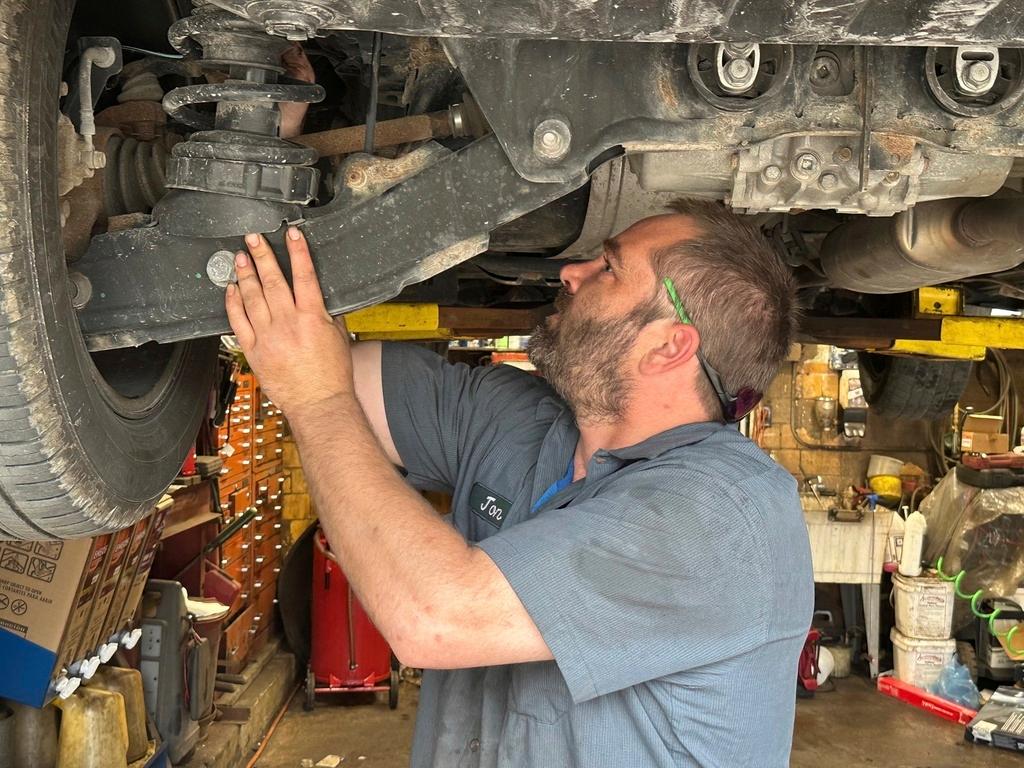 Mechanic Jon Guthrie inspects the underside of a 2014 Honda Ridgeline pickup truck