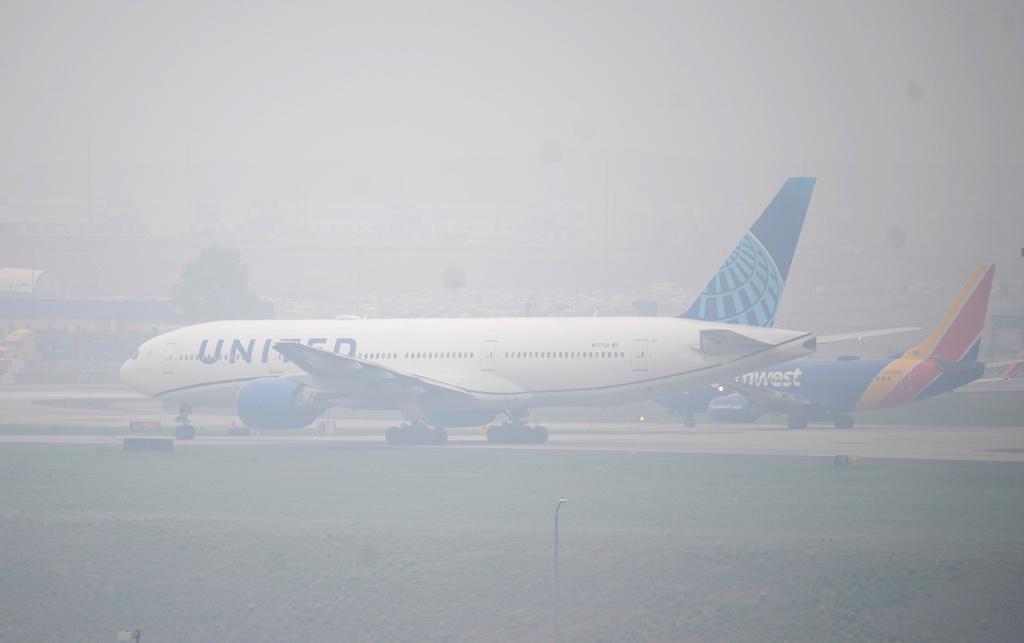 Jetliners taxi in heavy smoke at Denver International Airport