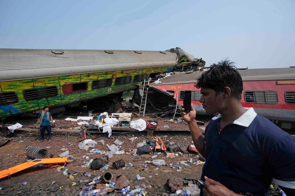 People inspect the site of passenger trains that derailed in Balasore district, in the eastern Indian state of Orissa, Saturday, June 3, 2023.