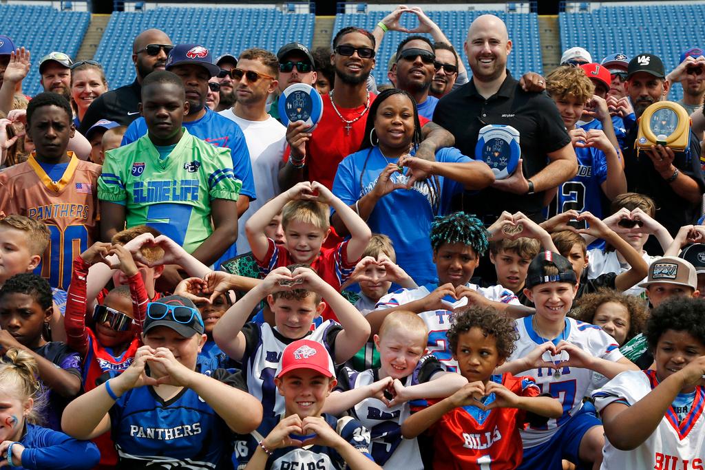 Buffalo Bills defensive back Damar Hamlin (top, middle) holds a AED, (Automatic Electronic Defibrillator) to help resuscitate heart attack victims