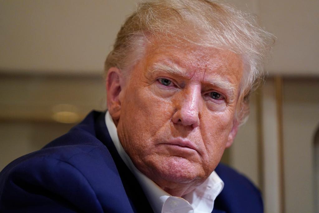 Former President Donald Trump listens as he speaks with reporters while in flight on his plane after a campaign rally at Waco Regional Airport, in Waco, Texas