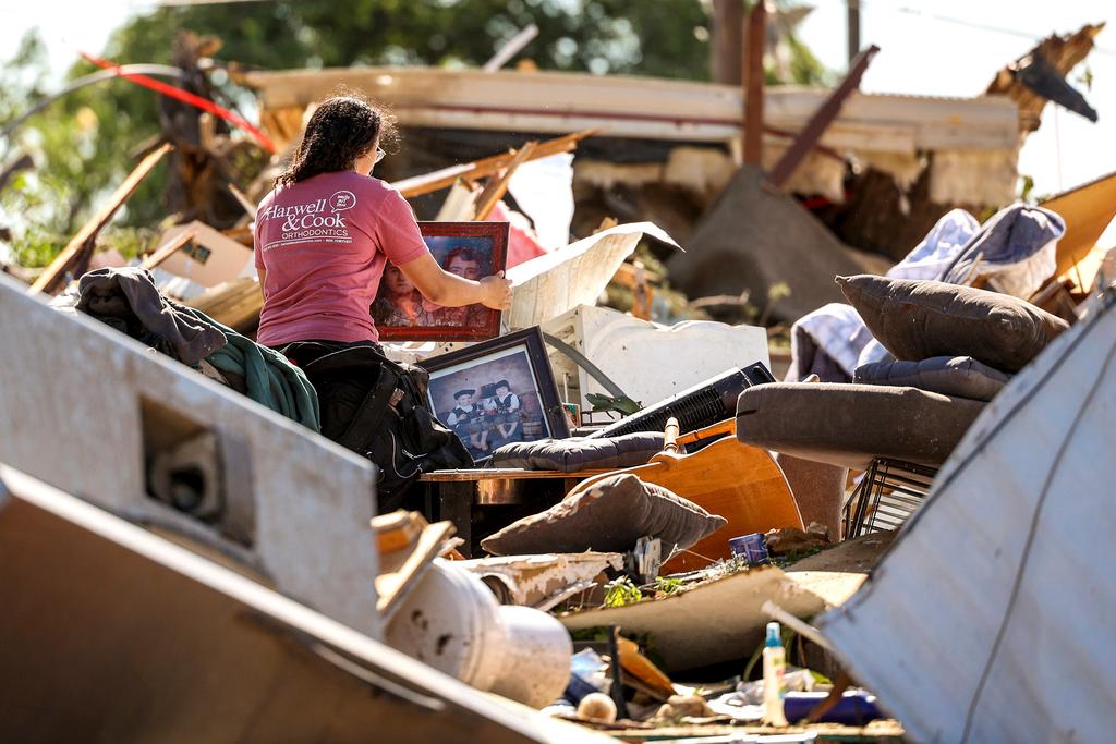 Mariana Valenzuela sifts through the tornado damaged home of her aunt and cousins in Perryton, Texas, Friday, June, 16, 2023.
