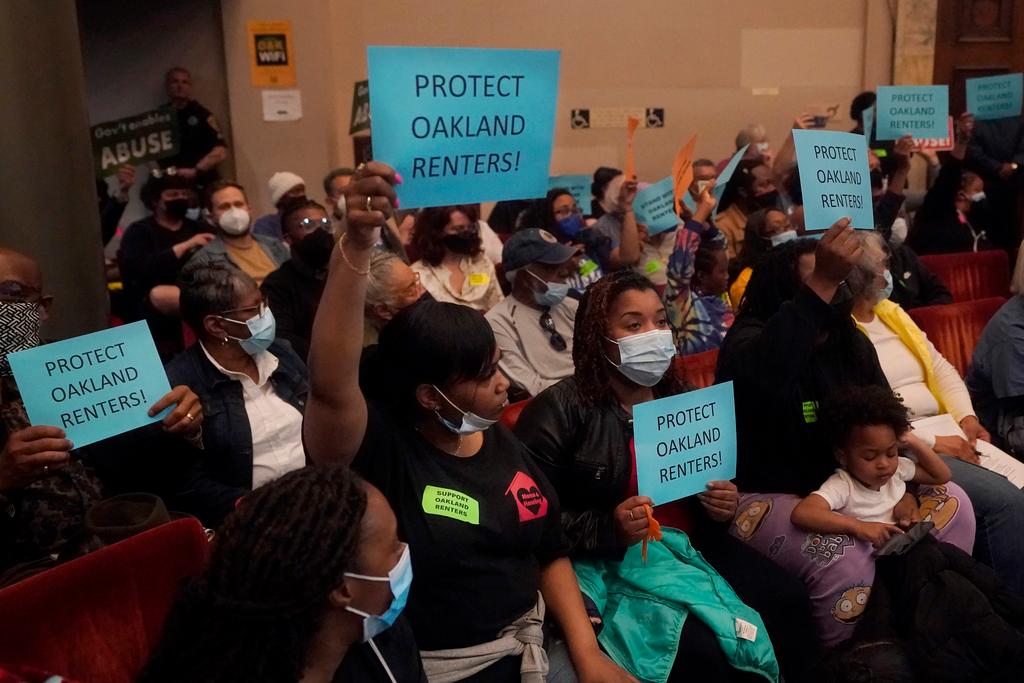 People supporting renters and a ramp down of the eviction moratorium hold up signs during a Oakland City Council special community and economic development committee at City Hall in Oakland, Calif., Tuesday, April 11, 2023.