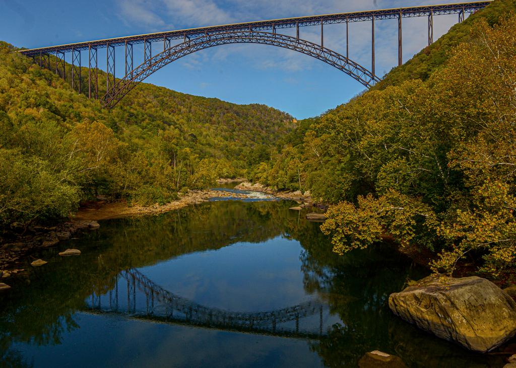 The Miss M. Rocks idles in the outflow of the New River's Old Nasty rapids, with the New River Gorge Bridge in the background.