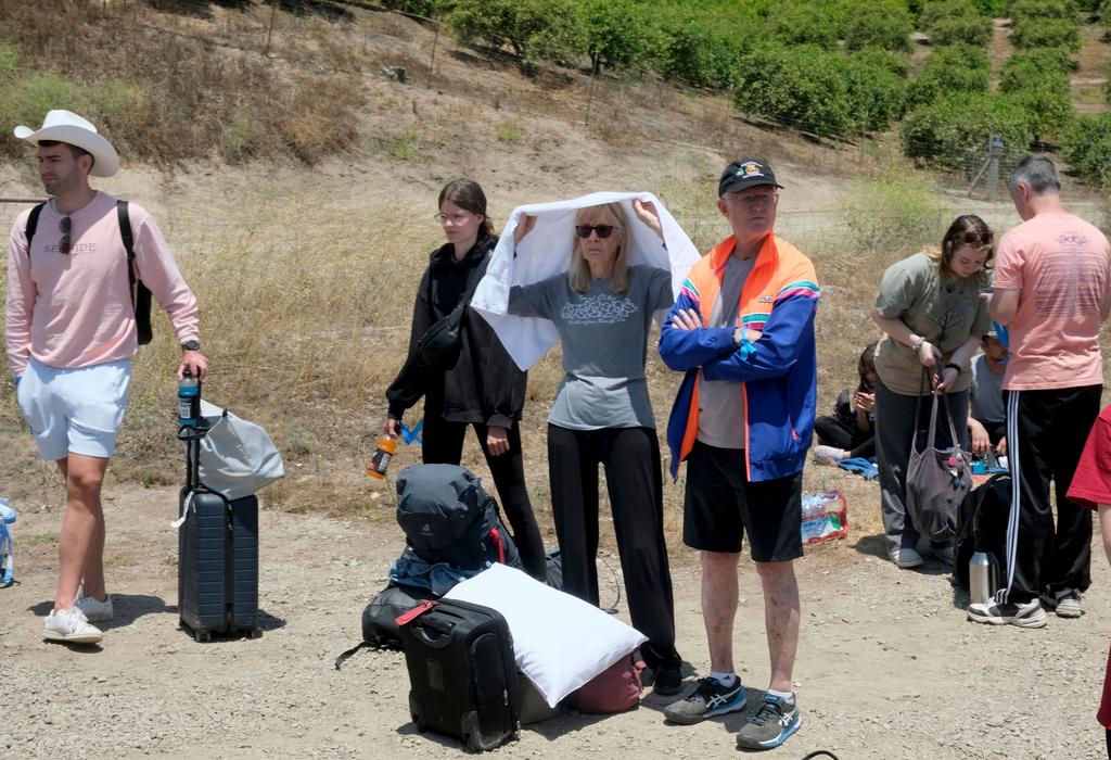 Passengers wait for transportation after their Amtrak train derailed in Moorpark, Calif.
