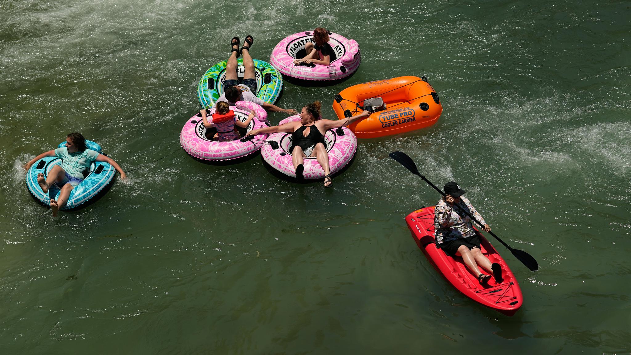 Six people floating on inner tubes in the water
