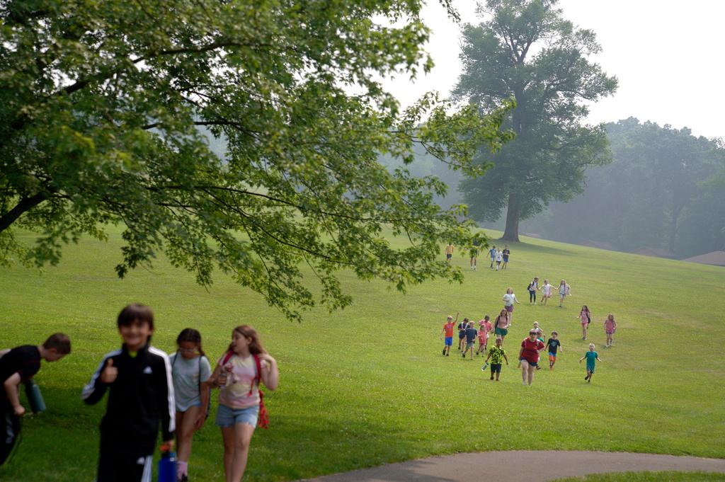 Kids walk across the YMCA Camp Kon-O-Kwee Spencer campground through smokey haze to their next indoor activity, in Zelienople, Pa.