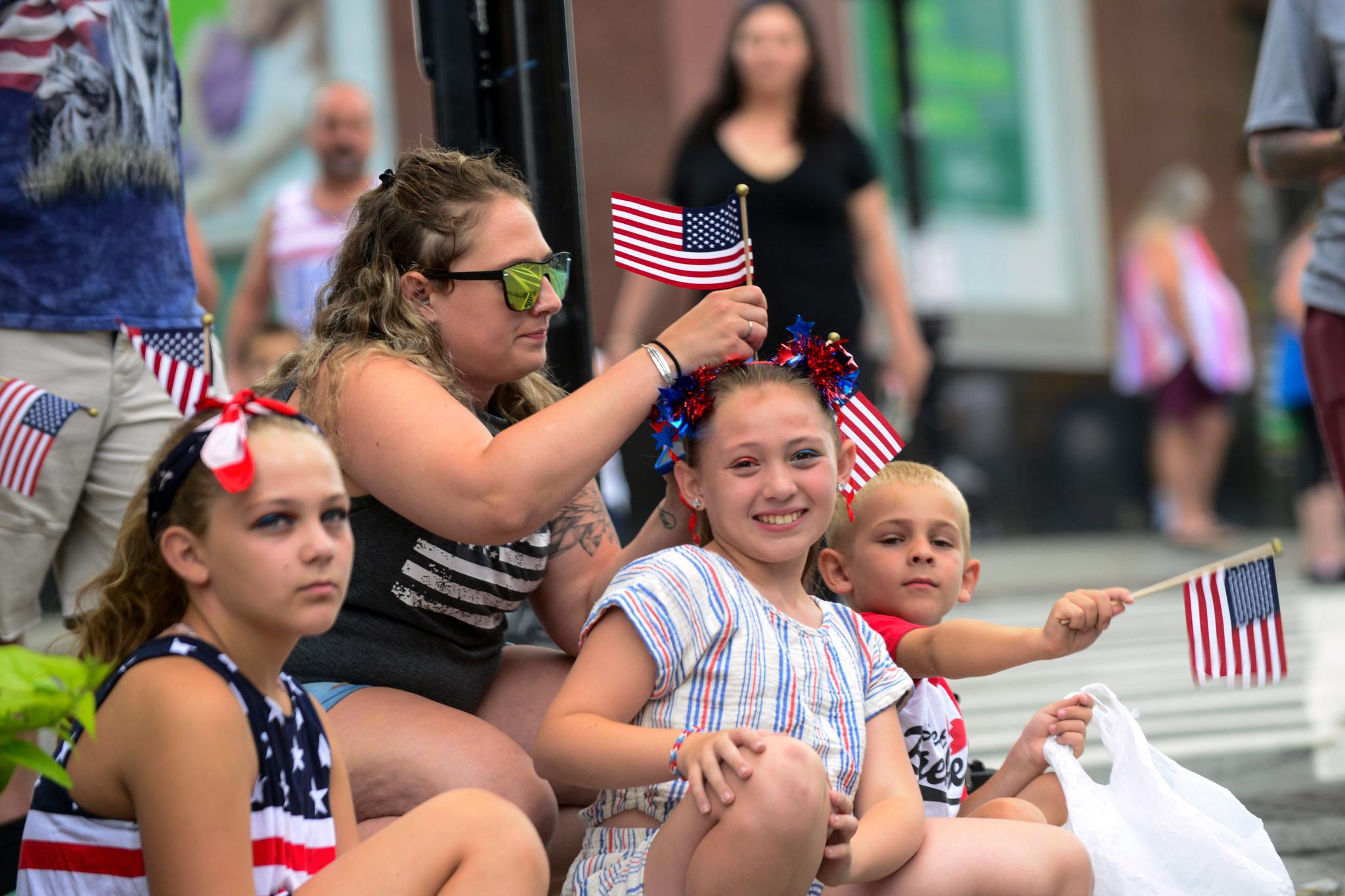 Hillary Hauer puts an American flag in the hair of her daughter, Danielle Hodgin, 9 years old, before the start of the annual Fourth of July parade, Tuesday, July 4, 2023, in Brattleboro, VT.