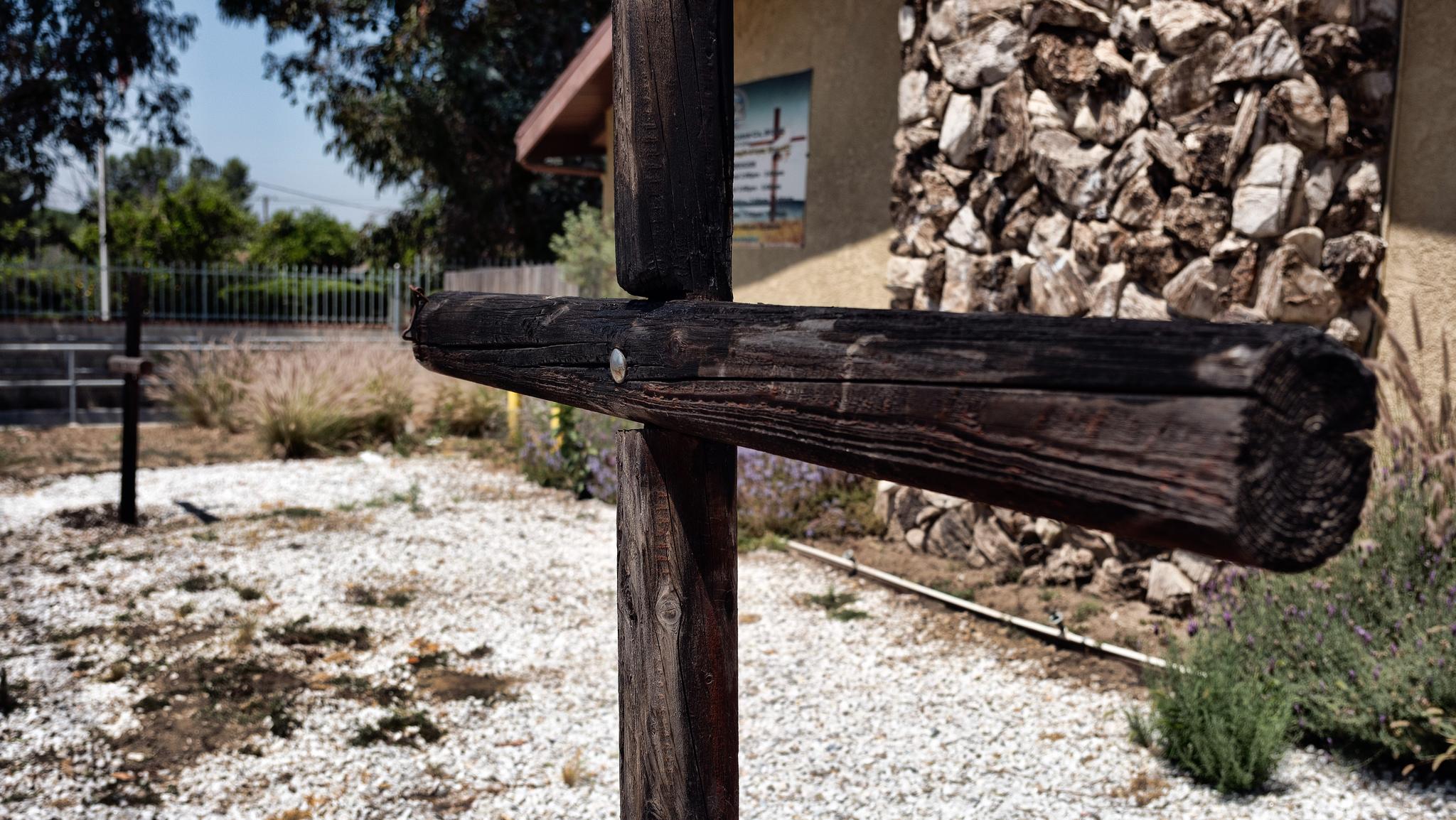 A burnt cross in front of a small church