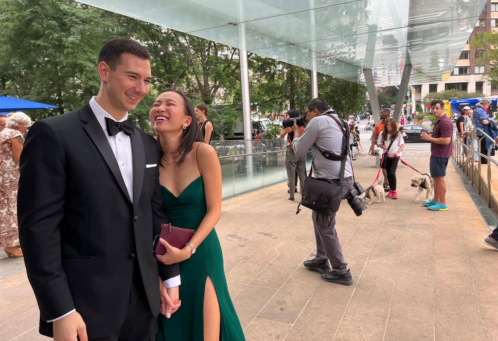 Alexander Fischer and Nina Oishi laugh and hold hands before taking part in a mass wedding at New York's Lincoln Center