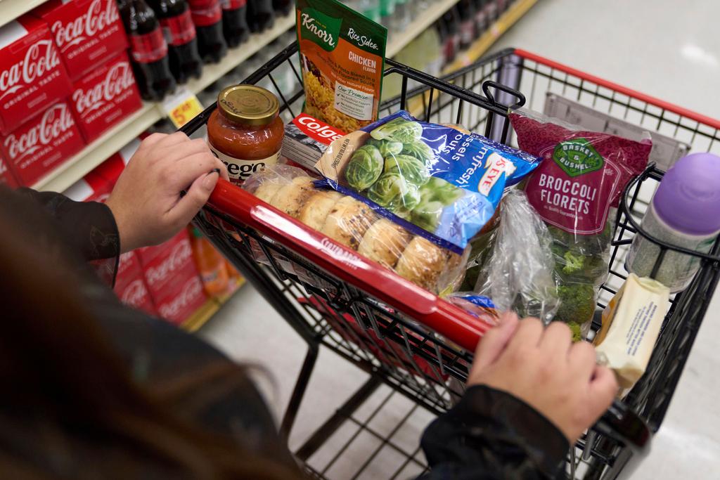 A food shopper pushes a cart of groceries at a supermarket in Bellflower, Calif., on Monday, Feb. 13, 2023. Over the past 12 months, gas prices have dropped, grocery costs have risen more slowly and used cars have become less expensive.