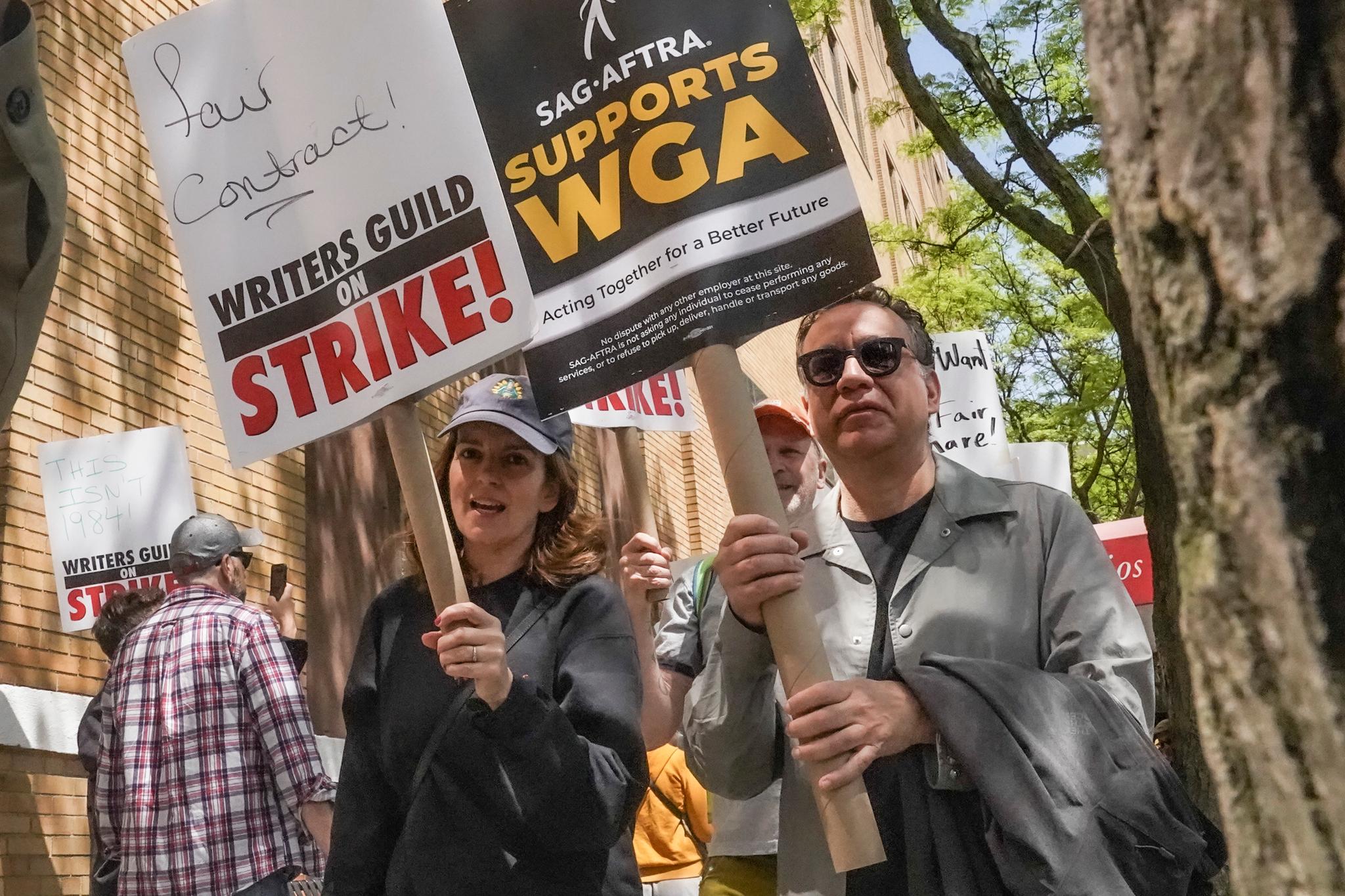 Actors and comedians Tina Fey, center, and Fred Armisen, right, join striking members of the Writers Guild of America on the picket line during a rally outside Silvercup Studios, Tuesday May 9, 2023, in New York.