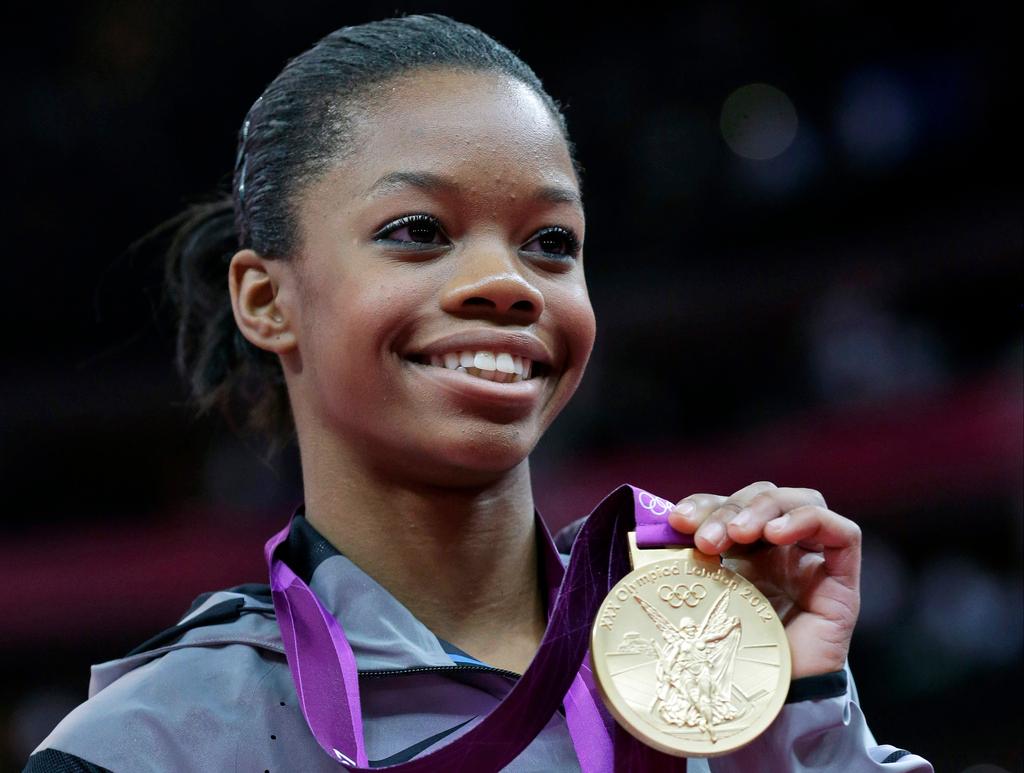 U.S. gymnast Gabby Douglas displays her gold medal during the artistic gymnastics women's individual all-around competition at the 2012 Summer Olympics in London, Aug. 2, 2012.