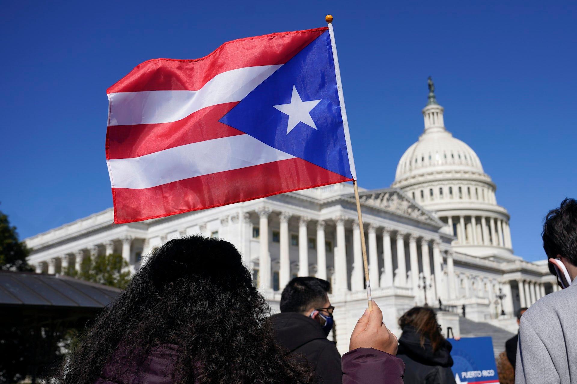 A woman waves a Puerto Rico flag to support Puerto Rican statehood