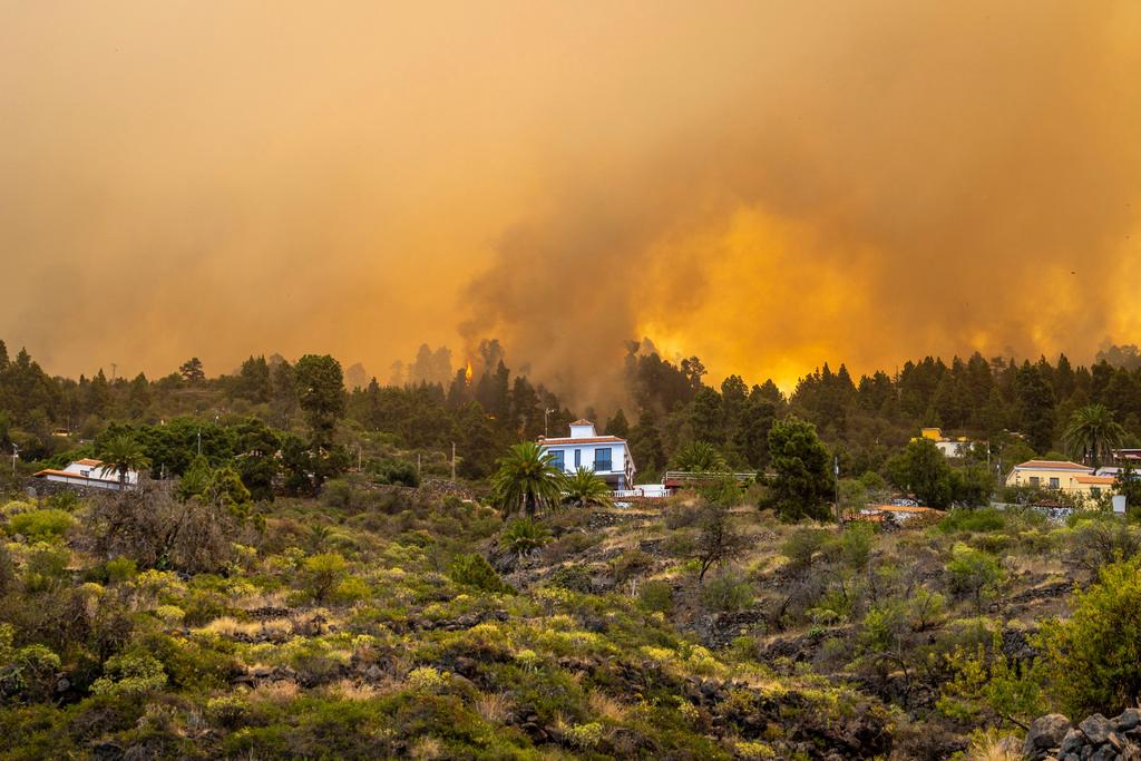 A view of a burning forest fire close to homes, near Puntagorda on the Canary Island of La Palma, Saturday, July 15, 2023. Spanish authorities say that they have preemptively evacuated some 500 people to avoid a wildfire that has broken out on the Canary island of La Palma. The fire coincides with a heatwave that is hitting southern Europe. Spain recorded record high temperatures in 2022 and this spring as it endures a prolonged drought.