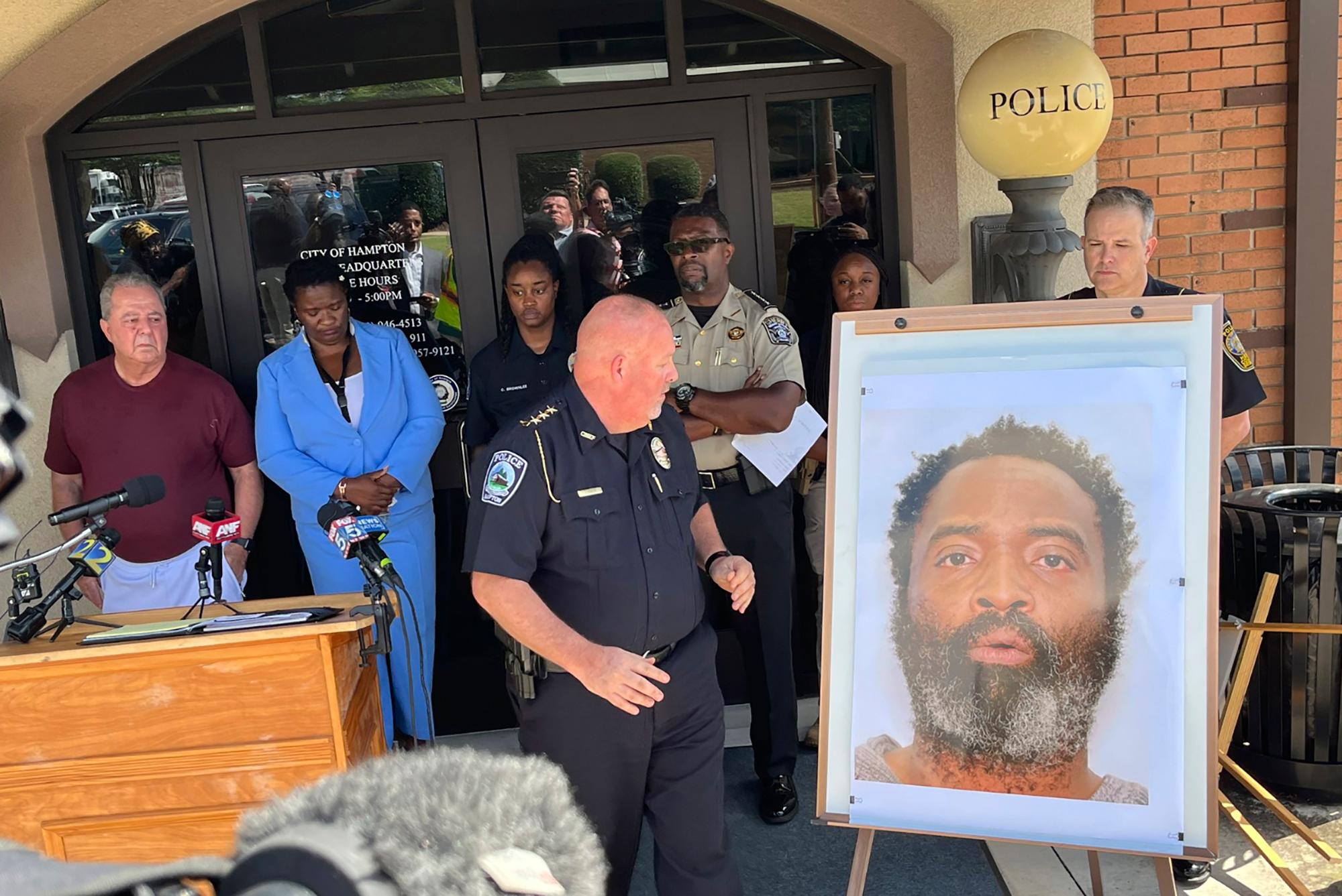In this photo tweeted by WSB-TV's Steve Gehlbach, Hampton Police Chief James Turner, center, stands next to a mounted picture of suspect Andre Longmore during a news conference in Hampton, Ga., Saturday, July 15, 2023.