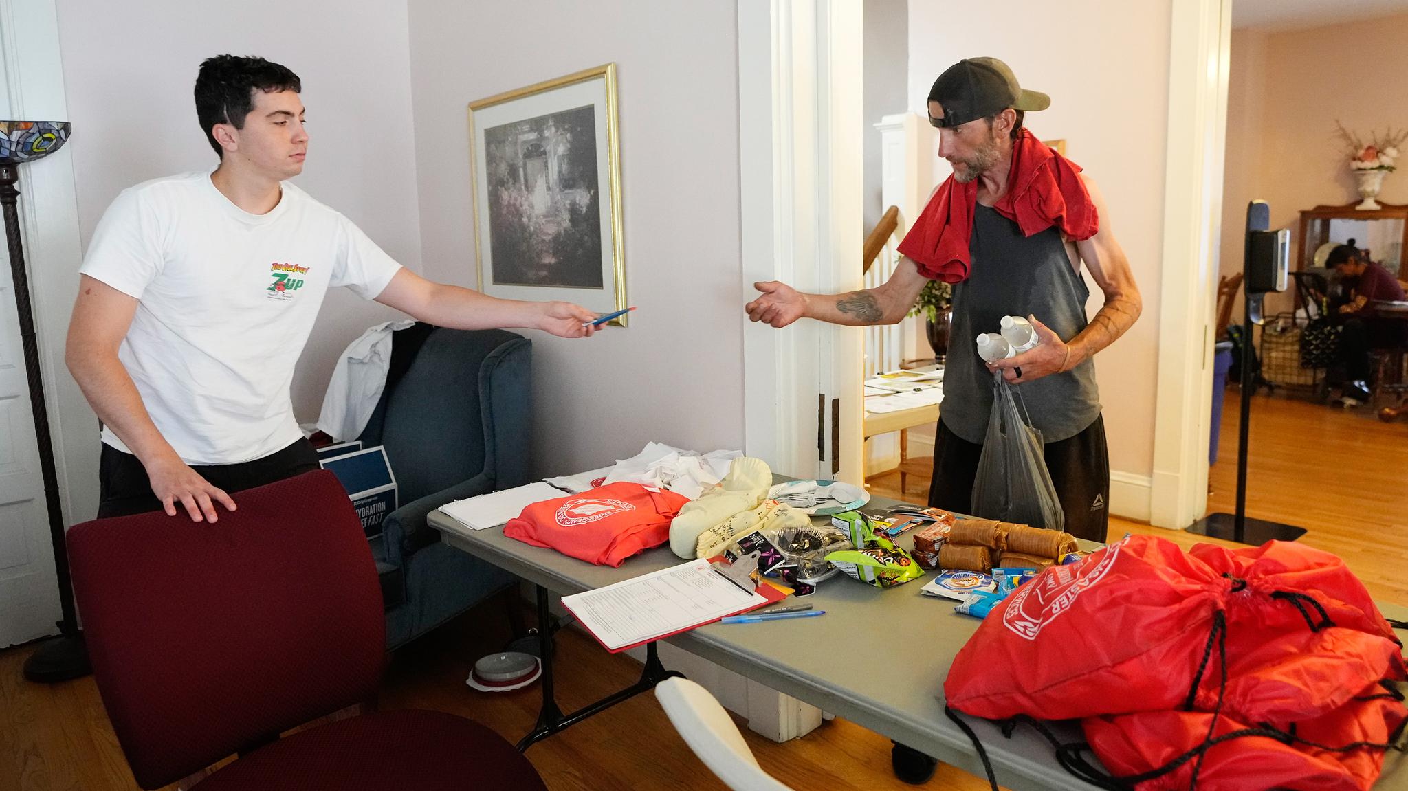 A young person and a man inside of a cooling station. Man is receiving an item.
