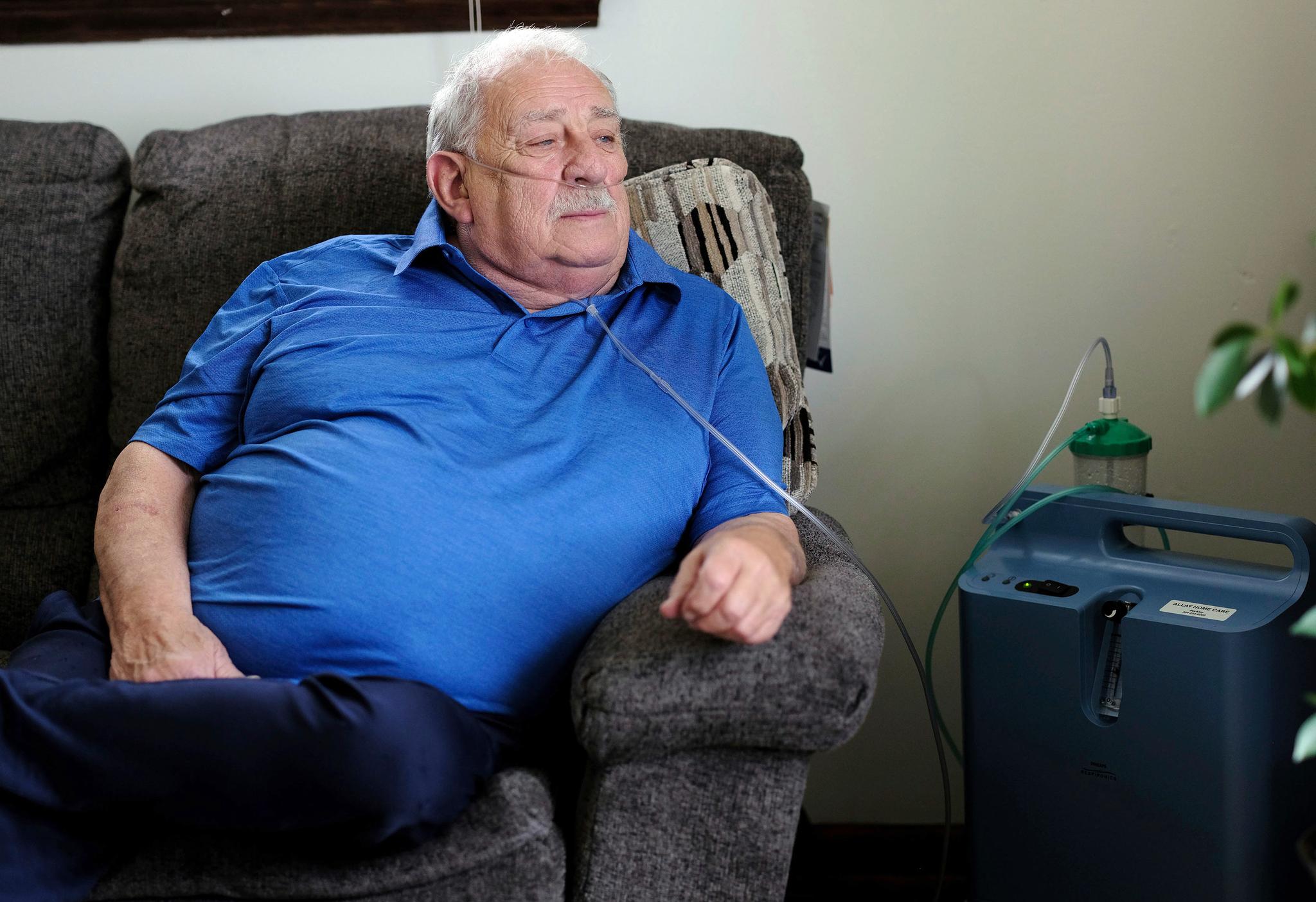 Man in a blue shirt with an oxygen tank