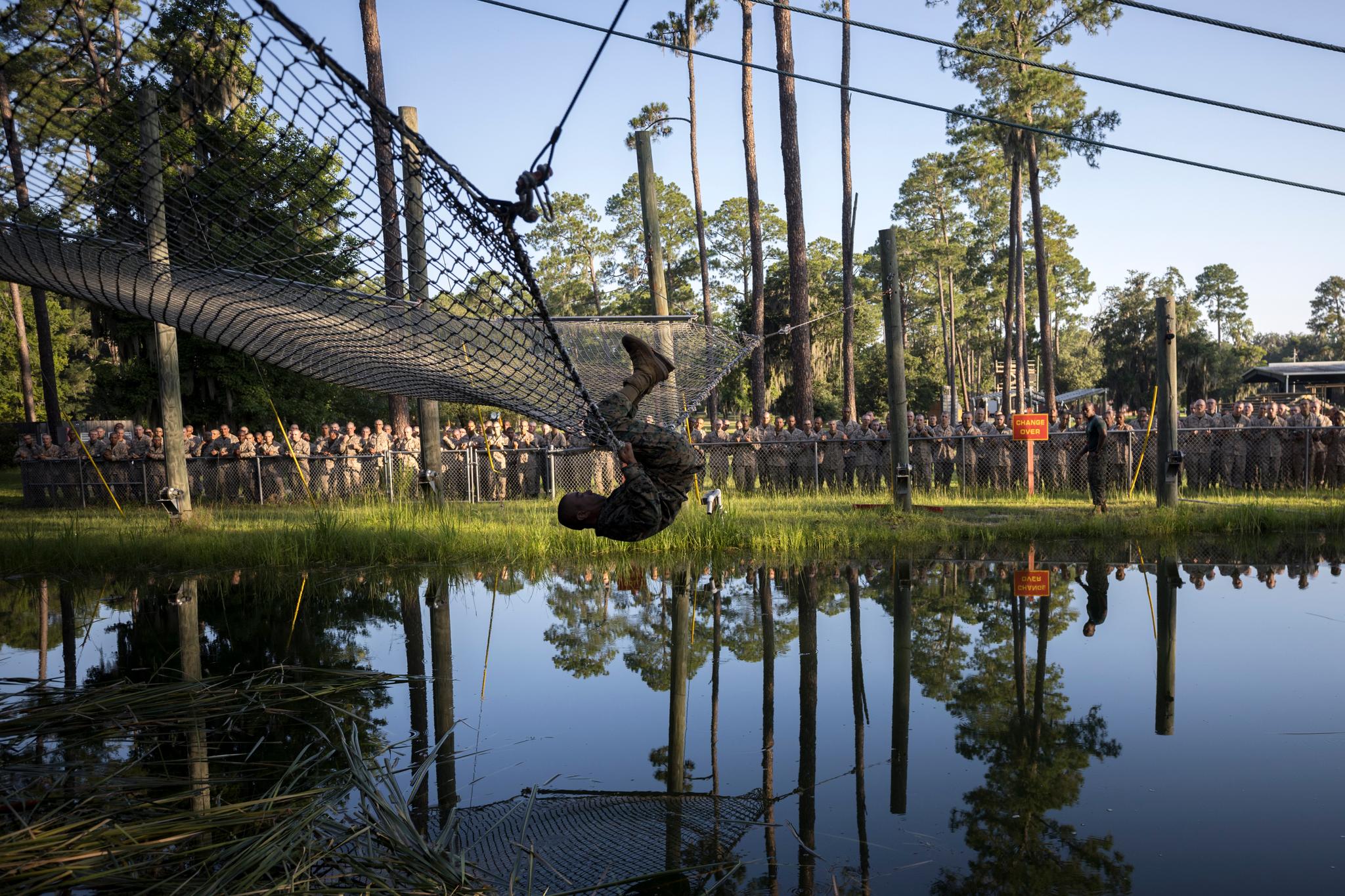 A U.S. Marine Corps recruit demonstrates to a group of recruits how to exit a safety net after failing an obstacle during training at the Marine Corps Recruit Depot, Wednesday, June 28, 2023, in Parris Island, S.C.