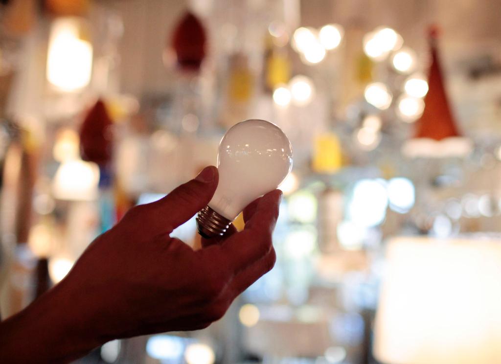 Manager Nick Reynoza holds a 100-watt incandescent light bulb at Royal Lighting in Los Angeles