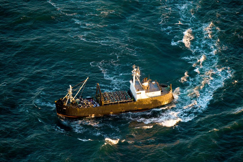 A crabbing vessel turns below a U.S. Coast Guard flyover inspection of crabbing ships along the Washington and Oregon coasts near Astoria, Ore.