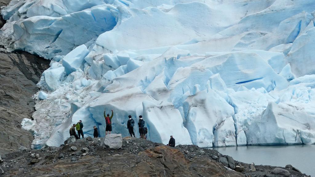 A group of people take in the views of the Mendenhall Glacier on June 8, 2023, in Juneau, Alaska.