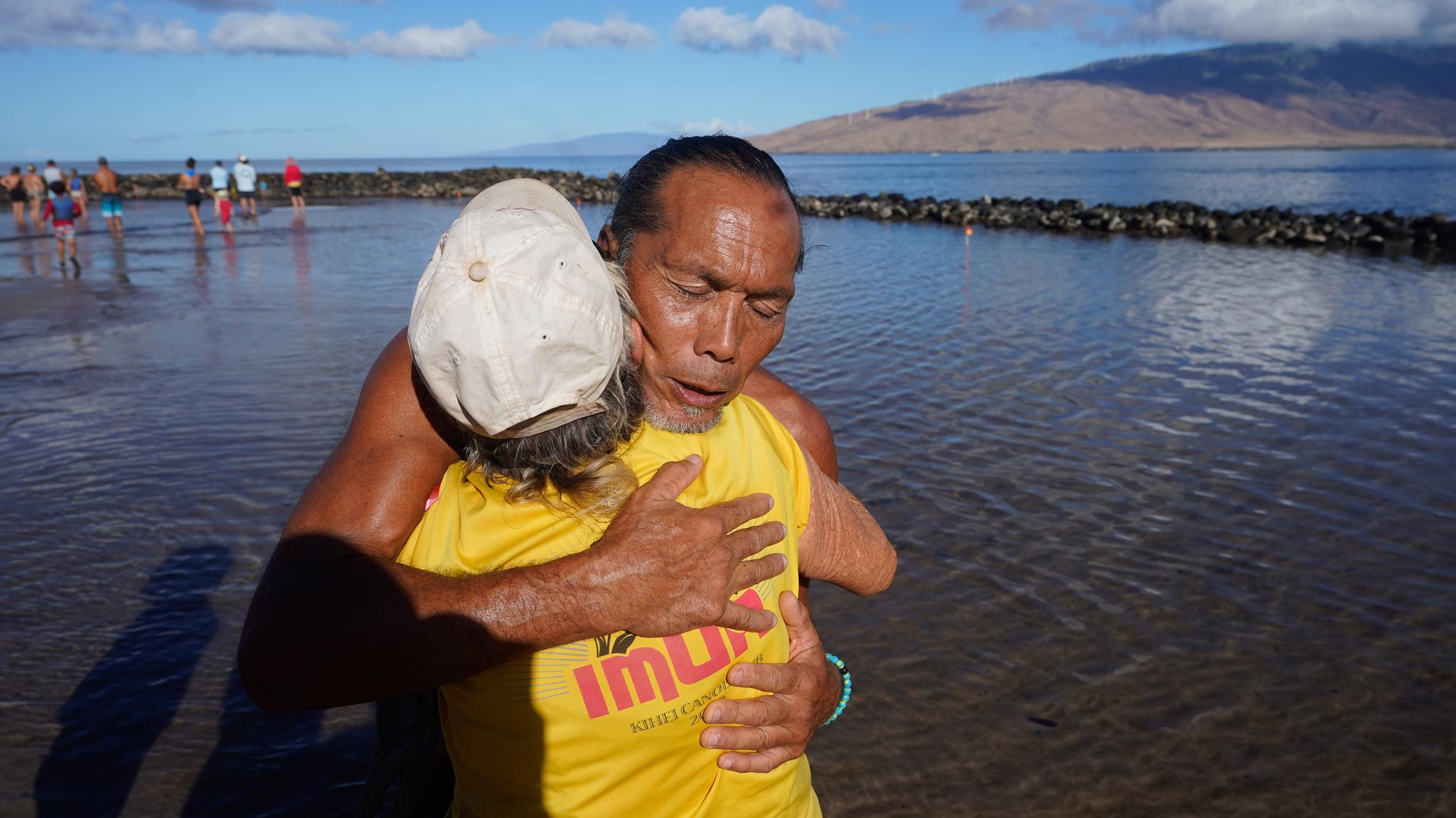 Two people hugging with water in the background