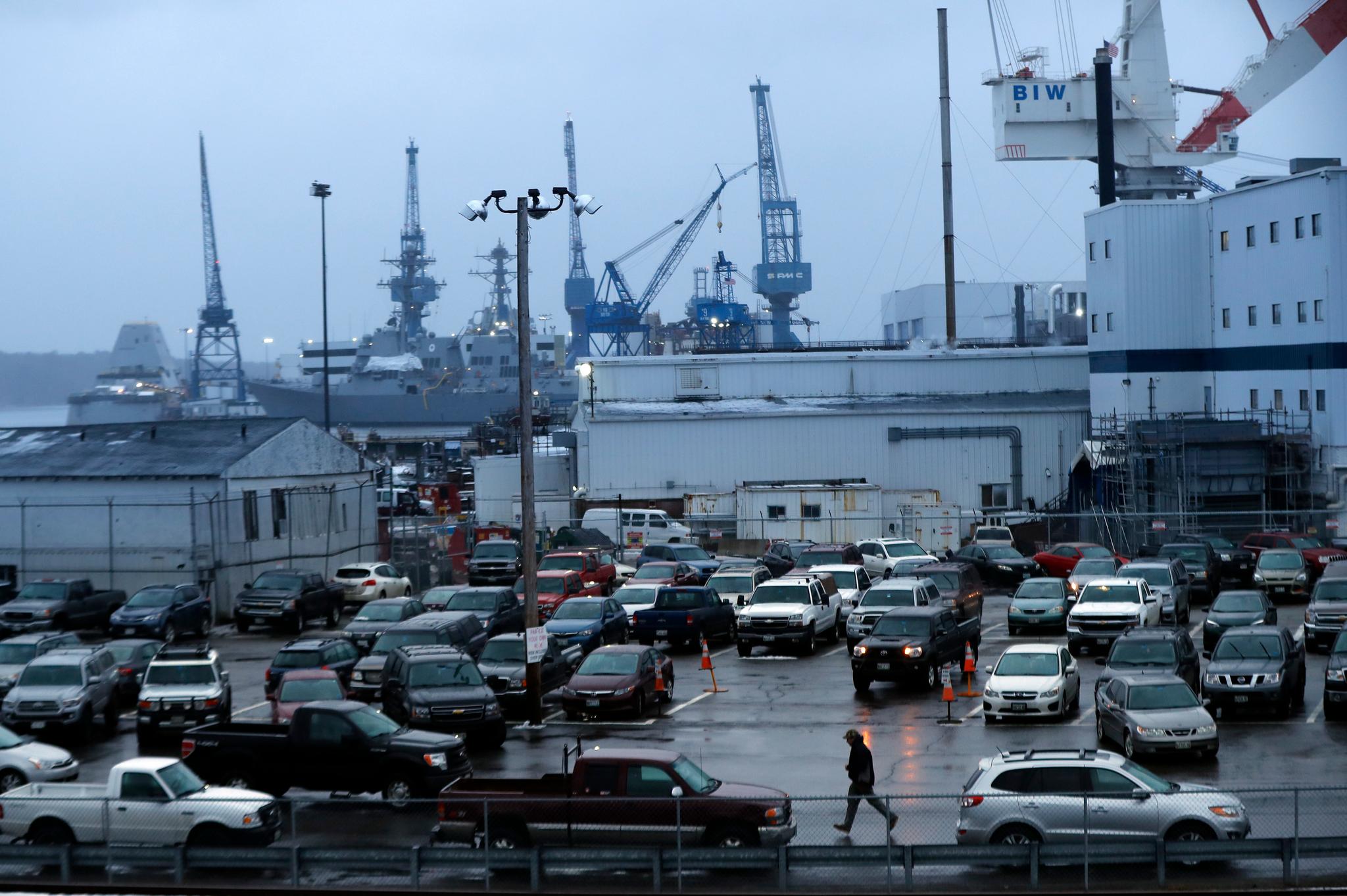  A shipyard worker, below center, walks to his car at the end of a workday at Bath Iron Works in Bath, Maine, Tuesday, Jan. 3, 2017. 