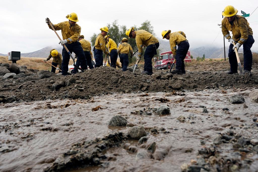 Members of Cal Fire Pilot Rock 6 crew, out of Crestline, Calif., clear mud off the side of the road in the aftermath of Tropical Storm Hilary, Monday, Aug. 21, 2023, in Yucaipa, Calif.