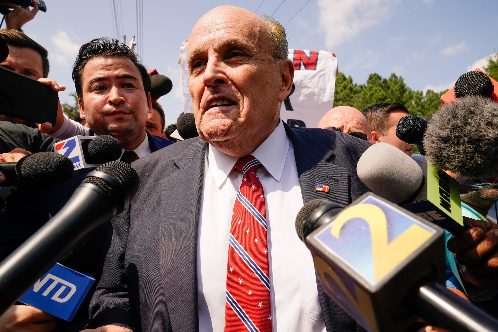 Former Mayor Rudy Giuliani surrounded by reporters