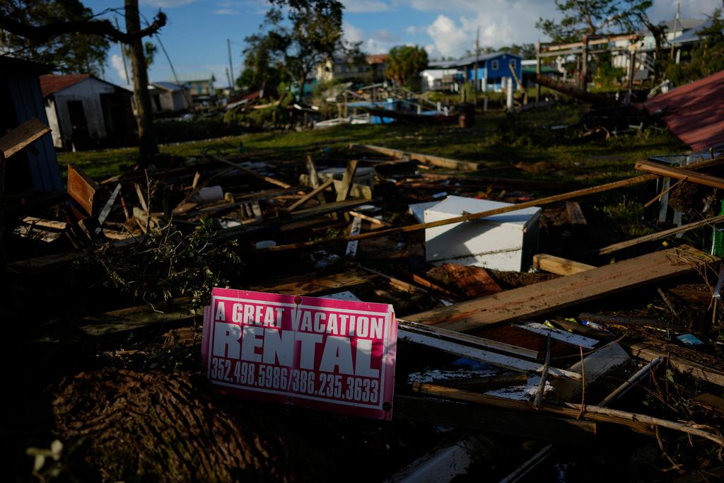 A sign advertising a vacation rental is attached to a piece of wood amid the scattered debris of destroyed homes and businessees in Horseshoe Beach, Fla., Thursday, Aug. 31, 2023, one day after the passage of Hurricane Idalia.