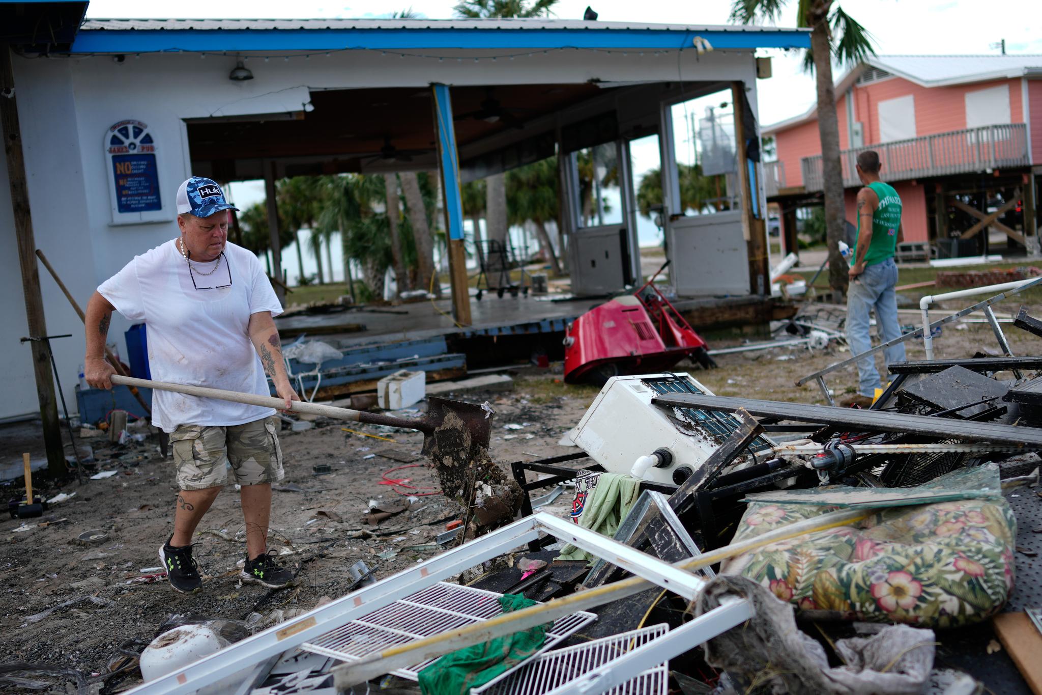 Woman shoveling debris away from a building