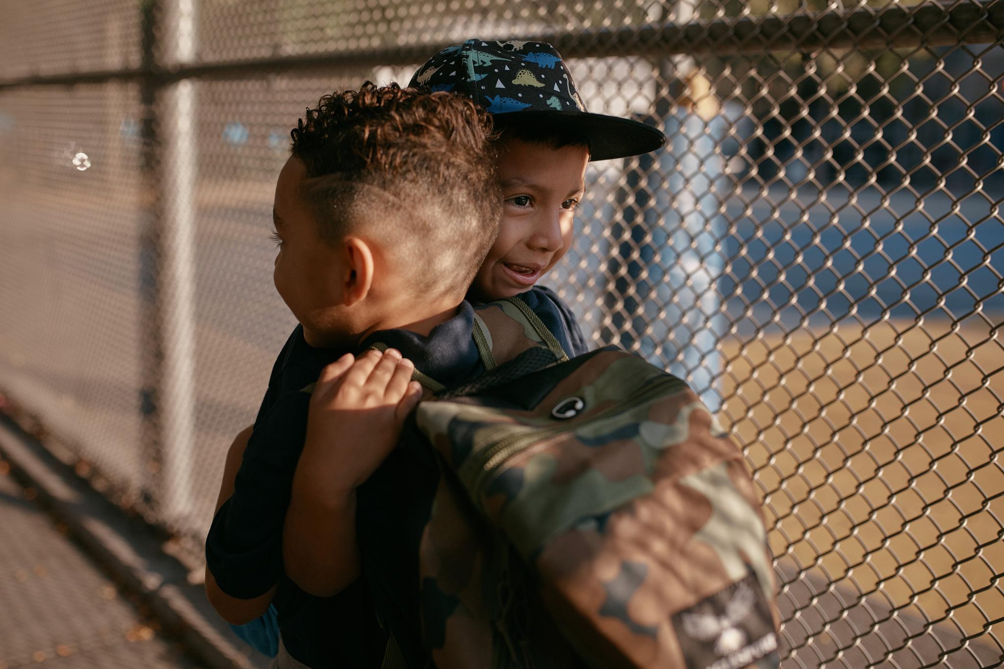 Two little 5-year-old boys hugging on the playground