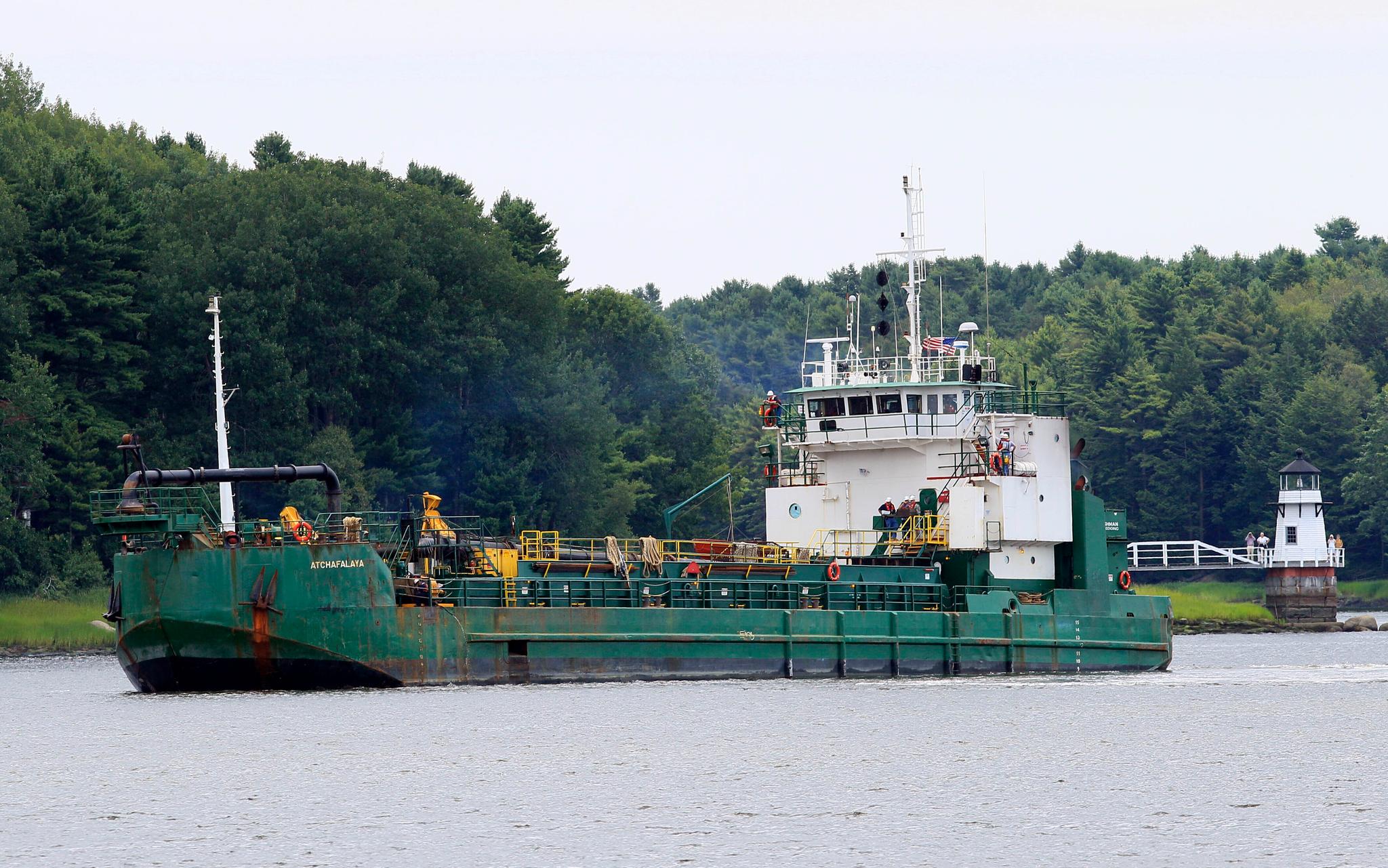 Spectators watch as a dredger works to deepen a shallow channel in the Kennebec River, upstream from the Doubling Point Lighthouse, Aug. 5, 2011, in Arrowsic, Maine.