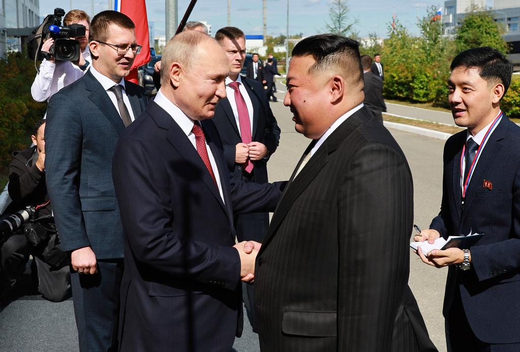Russian President Vladimir Putin and North Korea's leader Kim Jong Un shake hands during their meeting 