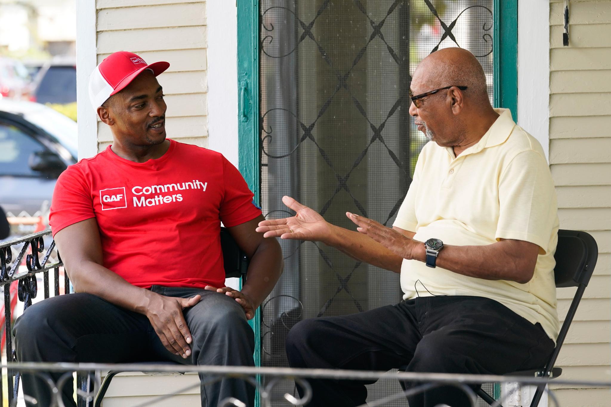 Two men talking on a porch