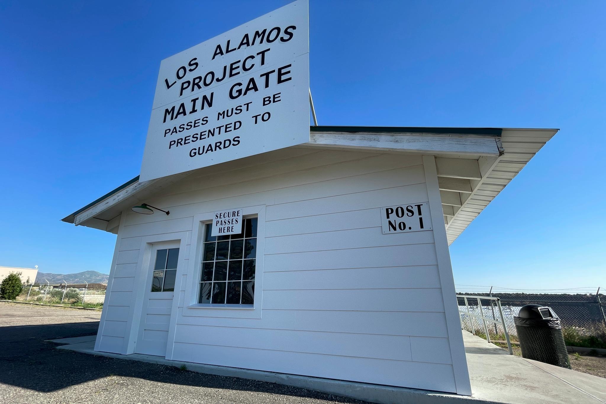 A sign marks a roadside rest stop that has been made to look like the historic security gate that all Manhattan Project workers passed through in Los Alamos, N.M., on June 26, 2023.