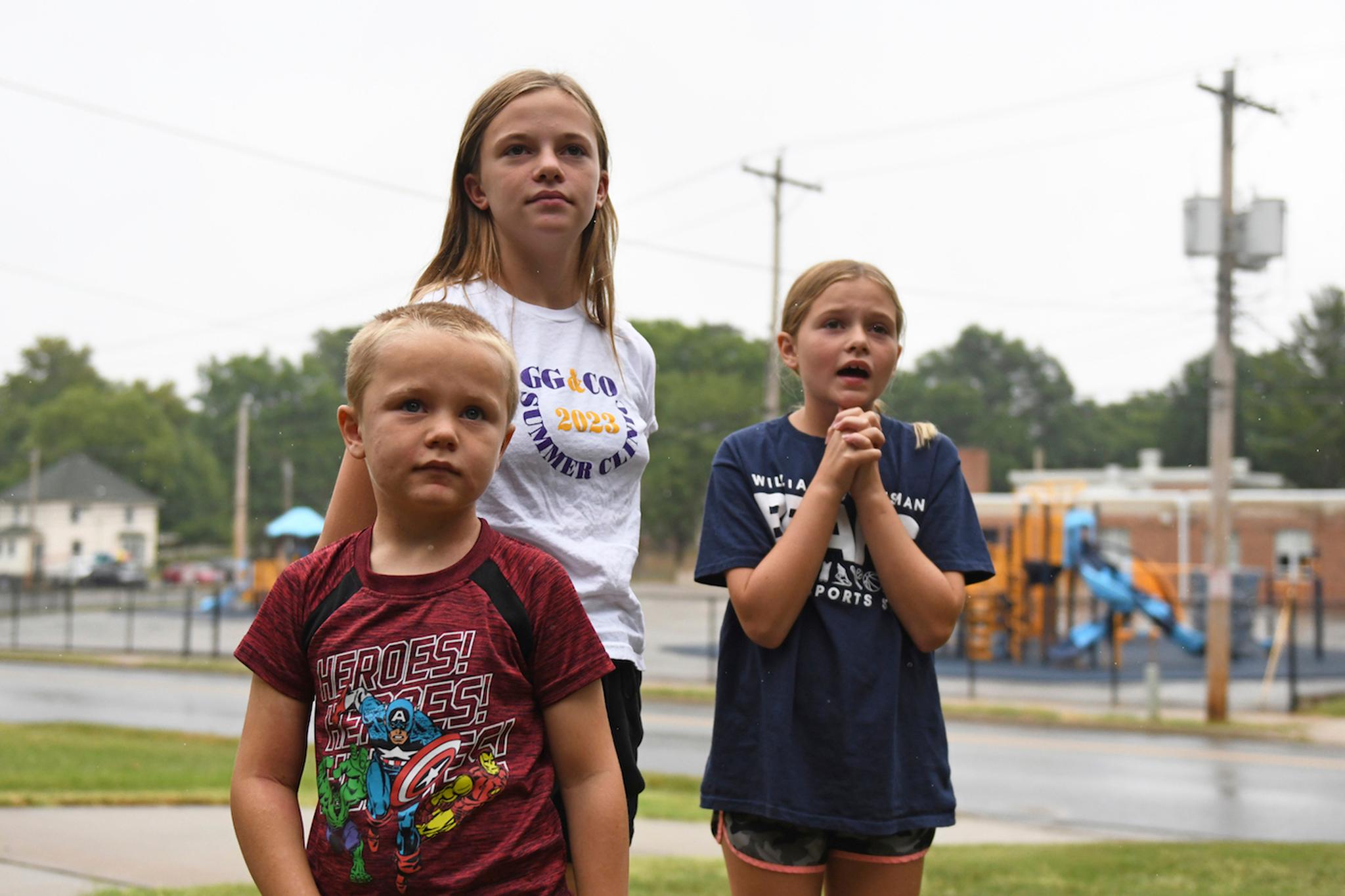 Hudson, 7, left, Callahan, 13, middle, and Keegan Pruente, 10, right, stand outside their school on their first Monday home during the new four-day school week on Monday, Sept. 11, 2023, in Independence, Mo.
