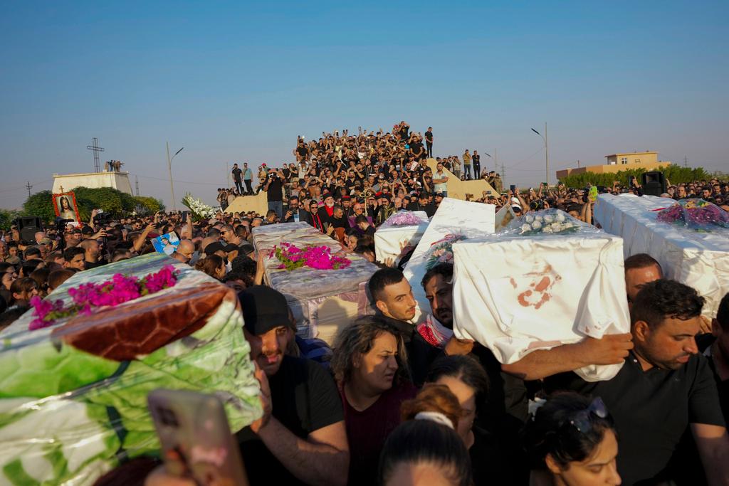Friends and relatives attend the funeral of people who died in a fire during a wedding ceremony in Hamdaniya, Iraq